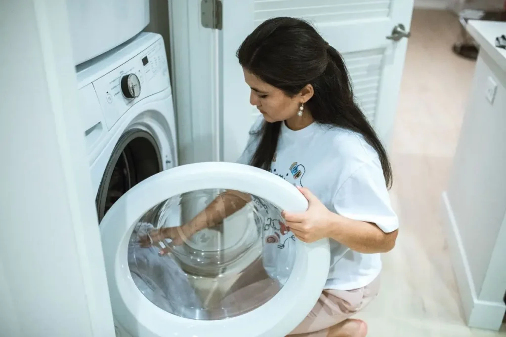 Loading linen sheets into a washing machine with enough space for gentle washing.