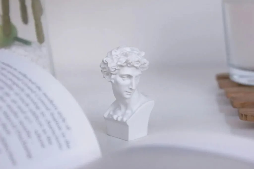 Classical bust beside an open book representing ancient philosophy and learning