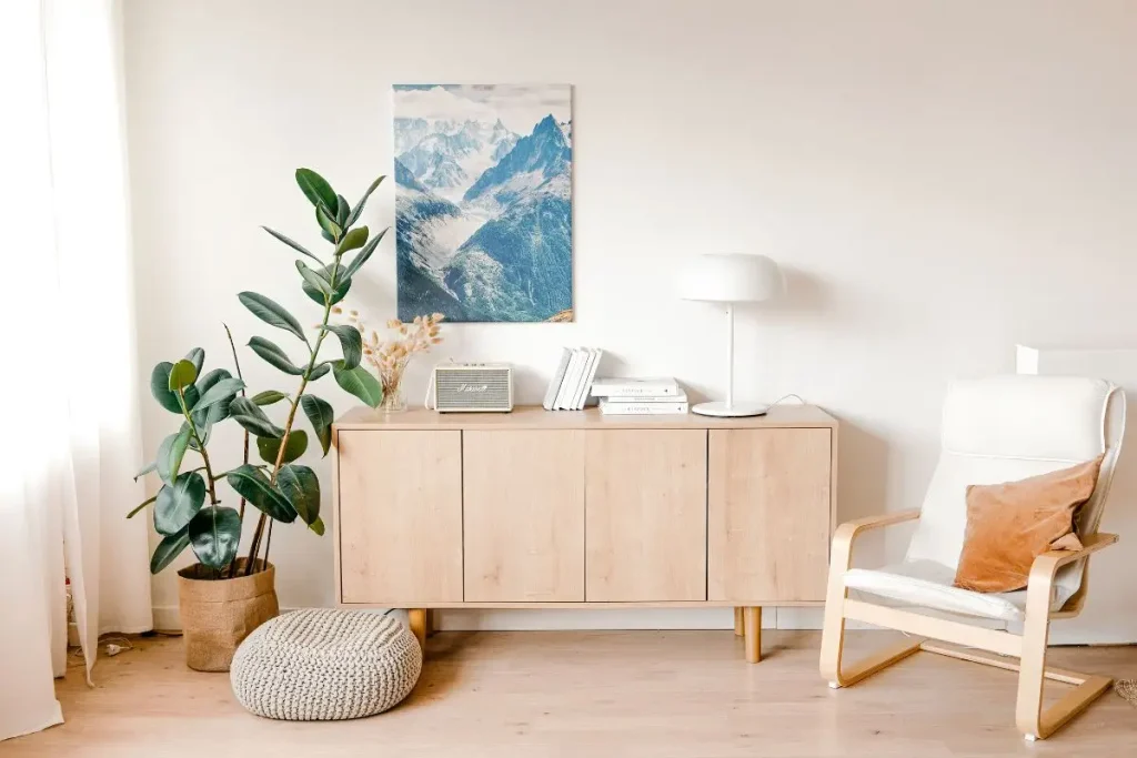 Cozy reading nook with a comfortable armchair, natural light, wood furniture, and indoor plant