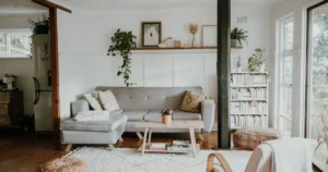 Warm and welcoming living room with natural textures, plants, wood furniture, and abundant natural light